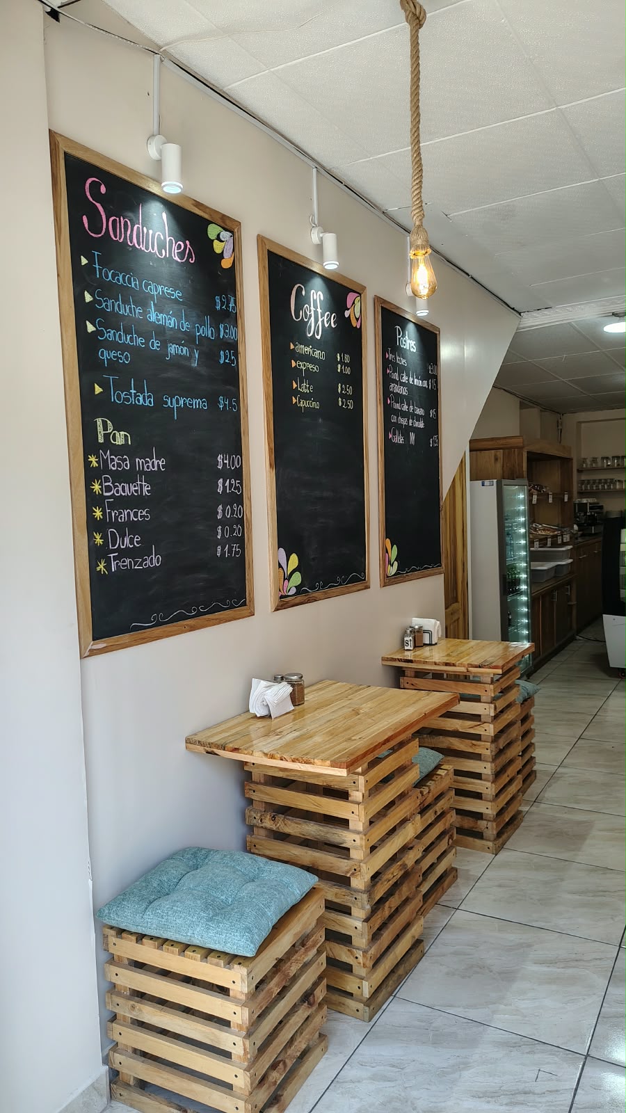 Pizarras con la carta de sánduches, café y postres sobre las mesas